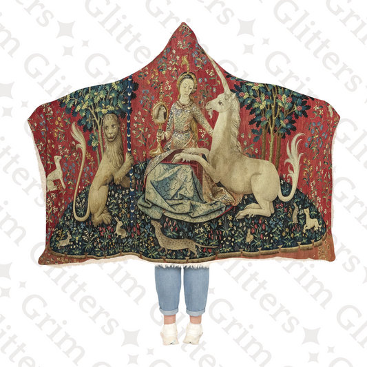 Wrap yourself in medieval elegance with The Lady and the Unicorn (Sight) Snuggle Cloak from Grim Glitters. Inspired by the iconic Unicorn Tapestry.